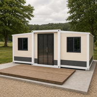 Maison conteneur pliable extensible à motif de briques blanc crème avec base grise et fenêtres coulissantes pour le glamping en milieu de campagne