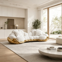 Canapé multiplace incurvé en bouclette blanche avec base en fibre de verre sculptée dorée et table basse ronde en pierre pour salon de luxe