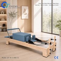 Reformer de Pilates en bois d'érable bleu ardoise avec rail fixe, barre de repose-pieds intégrée et barre à ressorts réglable pour studios contemporains