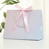 Sac en papier imprimé conçu sur mesure pour l'emballage de cadeaux de boutique de mode gaufrage par stratification mate pour la poudre libre de crème pour le visage