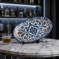 Plat de service ovale en céramique peint à la main, style Iznik turc, orné de motifs floraux tulipes scarlets et bordure marine, idéal pour la cuisine du Moyen-Orient