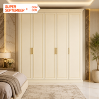Armoire intégrée moderne crème avec portes à panneaux encastrés et finition dorée, dressing de luxe léger, rangement 5 portes