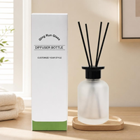 Bouteille diffuseur en verre dépoli rond avec bouchon noir et bâtonnets en rotin pour l'emballage de parfums d'intérieur