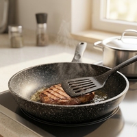 Ustensile de cuisine en gros : Spatule ajourée antiadhésive en acier inoxydable avec manche en nylon et TPR, légère, écologique, antidérapante, noire