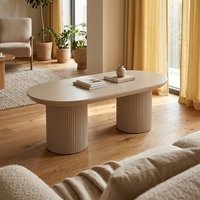 Table basse ovale moderne de style industriel avec piétement cylindrique cannelé blanc crème, mobilier minimaliste pour salon et aménagement intérieur