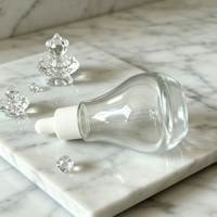 Flacon compte-gouttes en verre transparent rond créatif de 30 ml avec étiquettes personnalisées OEM/ODM pour le stockage d'huiles essentielles, de parfums et d'essences