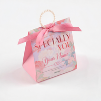 Boîte à dragées personnalisée avec nom, motif floral violet, forme triangulaire, poignée en perles, ruban et nœud, emballage cadeau pour mariage