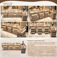 Table de présentation de bijoux de luxe avec plateau en marbre et pieds cylindriques en or brossé |   Vitrines en verre éclairées par LED avec socles en forme de dôme |   Personnalisable