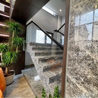 Carrelage en marbre gris foncé avec veines blanches Emperador Cloud pour escaliers de villa intérieurs avec garde-corps en verre trempé, design moderne
