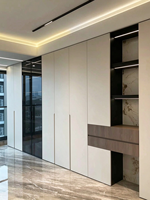 Revêtement mural blanc minimaliste combiné à des vitrines en verre, des étagères ouvertes et des bandes lumineuses LED créant un design de rangement.