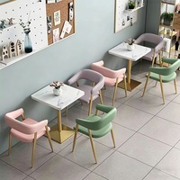 Table à manger en velours rose capitonnée avec plateau en marbre et base dorée, chaise à accoudoirs en velours rose pour café-bistro de luxe