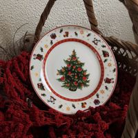 Assiette de Noël en céramique style rétro, motif de conte de fées avec Père Noël, cheval à bascule, sapin, agneau de Noël, et bordure géométrique rouge, idéale pour les fêtes