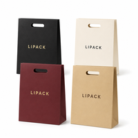   Sac en papier de luxe découpé avec poignée, logo gaufré à l'or et ruban pour emballage cadeau de bijoux, cosmétiques et boutiques