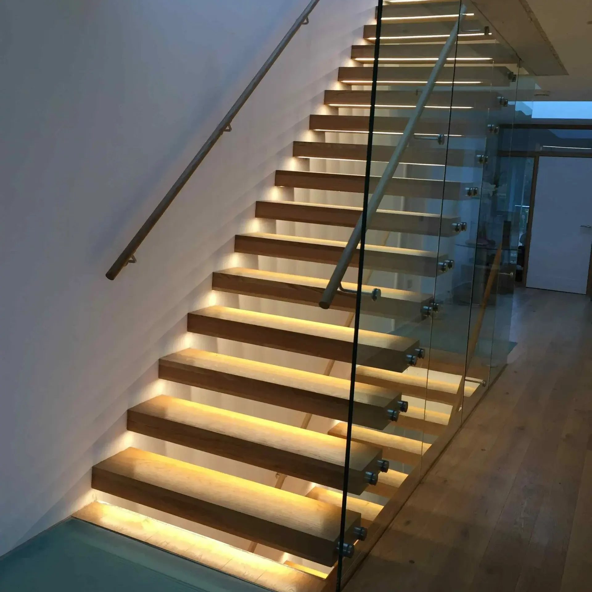 Escadas flutuantes cantilever de design sofisticado com degraus invisíveis em aço carbono, madeira maciça, marmore e corrimão de vidro