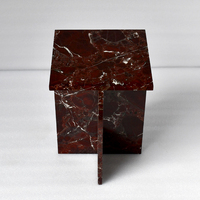 Table basse élégante en marbre scandinave bordeaux, sculpturale avec cadre en X, accent en pierre rouge profond, mobilier haut de gamme pour salon