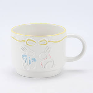 Taza de Cerámica Blanca <span class=keywords><strong>con</strong></span> Letras en Relieve y Decoración de Lazo <span class=keywords><strong>con</strong></span> Borde Azul para una Dulce Mesa de Pascua - Product Image 1