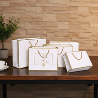 Sac en papier kraft de luxe avec estampage à chaud doré, pelliculage mat rose, poignée à cordon, emballage boutique pour bijoux, cadeaux et vêtements en gros