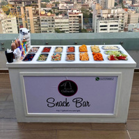 Chariot de présentation de bonbons personnalisé NIKA avec logo, en PVC et bois blanc, pour glaces et desserts, avec roulettes, pour mariages, fêtes et événements.