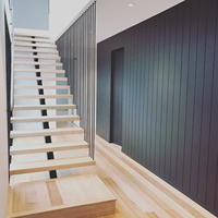 Escalier flottant moderne en cantilever avec balustrade verticale en métal noir et marches en bois massif pour l'intérieur de la villa