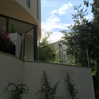 Système de garde-corps en verre pour terrasse, avec poteaux en verre mince et structure en acier inoxydable