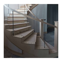 Escalier en colimaçon courbé sur mesure avec marches en acajou, balustres en fer forgé et main courante en laiton poli