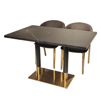 Table à manger en pierre frittée noire avec base en acier inoxydable et accents dorés