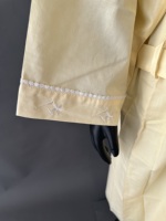 Elegante bata de algodón amarillo con bordado y ribete de encaje