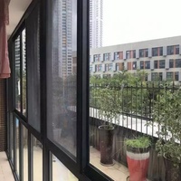 Fenêtre coulissante moderne à cadre fin en aluminium noir thermolaqué, à économie d'énergie, avec moustiquaire intégrée pour appartement de luxe