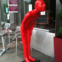 Sculpture d'art abstrait moderne grandeur nature en résine, couleur rouge, homme en résine et fibre de verre en position de salutation, statue de bienvenue en résine de style dessin animé, à vendre