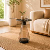 Table d'appoint ronde moderne et écologique avec plateau en acier inoxydable noir et base conique transparente fumée pour salon