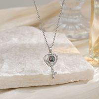 Collier de projection transfrontalier « Je t'aime » en 100 langues, pendentif cœur creux en forme de clé, élégant et tendance pour femme, en cuivre bambou