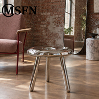 Table console moderne en acier inoxydable en forme de donut, finition miroir poli, centre creux, trois pieds, sculpture artistique pour salon