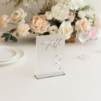 Numéros de table de mariage en acrylique blancs avec numéros sérigraphiés or et supports de présentation