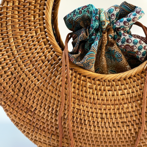 กระเป๋าถือสานทรงครึ่งวงกลมสไตล์ลำลองจากอินโดนีเซีย ทำมือ พร้อมสายสะพายไหล่  แบบเปิดปิดง่าย เหมาะสำหรับไปทะเล ฤดูร้อน  ตกแต่งด้วยโซ่ ตัวอักษร หมุด  และพู่ห้อย - Product Image 1