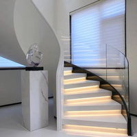 Escalier incurvé intérieur de villa moderne personnalisé en Chine, en métal durable et en marbre de pierre naturelle, design en verre avec garde-corps en verre