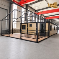 Maison conteneur moderne personnalisée à 2 chambres, pliable et extensible, avec structure en acier noir, porte coulissante en verre isolant, cuisine intégrée pour ADU de jardin