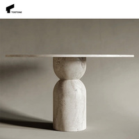 Table à manger ronde en travertin beige élégante de nouvelle conception Tostone avec pieds en forme de sablier pour les espaces à manger sophistiqués