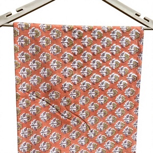 Tissu en coton premium imprimé à la main avec un motif traditionnel, fond pêche terre cuite doux, orné de motifs floraux crème. - Product Image 1