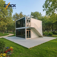 Maison conteneur préfabriquée mobile de 20 pieds sur 2 étages avec mur-rideau en verre, panneaux blancs, balcon, escalier et bureau à vendre