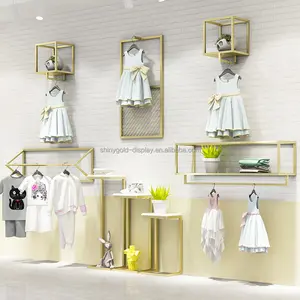 Negozio di vestiti per bambini Interior Design espositore da parete per indumenti per bambini Showroom espositore per abbigliamento per bambini in oro