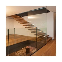 Système d'escalier courbé contemporain de luxe pour la maison avec garde-corps en verre trempé et marches en bois