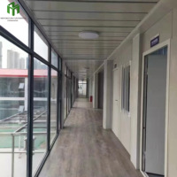 Maison conteneur à double étage avec mur-rideau en verre, bâtiment modulaire moderne en acier avec fenêtres panoramiques