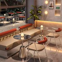 Ensemble de table et de chaises de café en métal moderne avec coussins orange et éclairage chaleureux pour les cafés et bars élégants