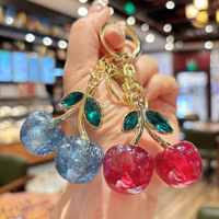 Al por mayor Llavero de moda ligero de cristal con cereza, de resina brillante con diseño de fruta y aleación de oro, colgante para bolso y llavero para coche