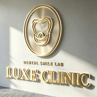 Plaque de signalisation personnalisée en métal 3D doré brossé avec logo dentaire en relief pour clinique dentaire de luxe, idéale pour l'identification de la marque à la réception.