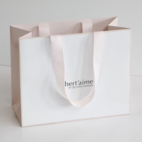 Sac cadeau en papier pour vêtements de luxe de marque privée personnalisée avec logo et poignée en ruban