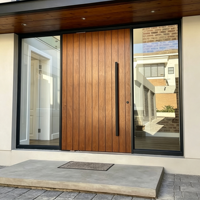 Portes d'entrée doubles résidentielles personnalisées avec cadre en bois, design de grille en verre et dessus arrondi