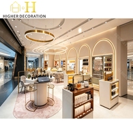 Vitrine de présentation de parfums de luxe sur mesure avec cadre doré multicouche et éclairage pour centre commercial et boutique de parfums