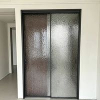 Porte coulissante moderne en verre ondulé à cadre noir fin, séparateur de pièce à intimité douce pour appartement et villa