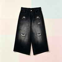 Culottes en jean noir déchiré pour hommes avec poches brodées, coupe large, style streetwear, vente en gros